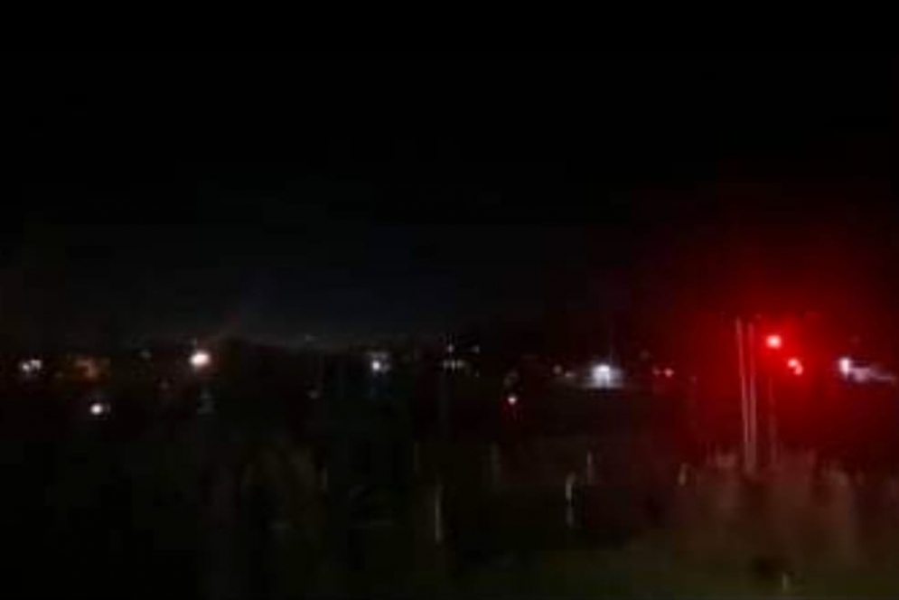 La luz roja del semáforo emerge en medio de la oscuridad.
